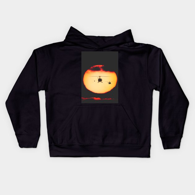 Bell Huey helicopters flying in front of the setting sun Kids Hoodie by Pitmatic